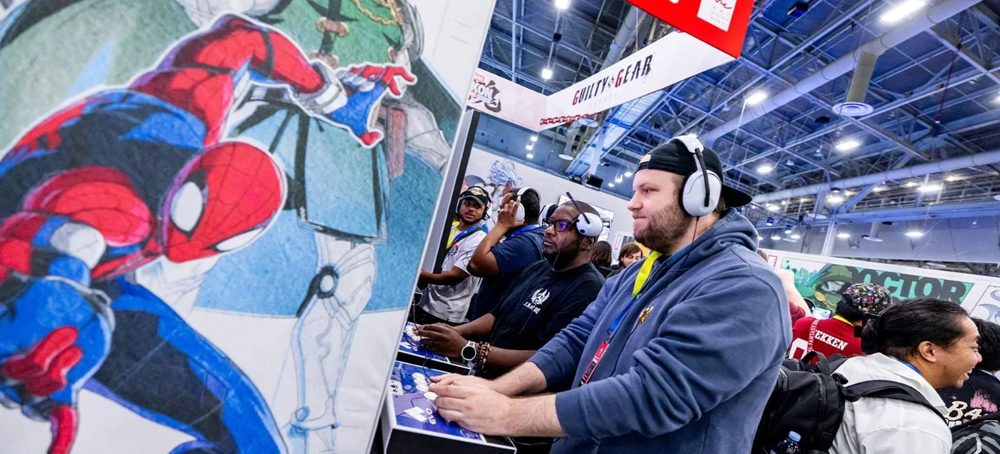 Jogadores testando jogos em arcade sticks em um estande de publisher